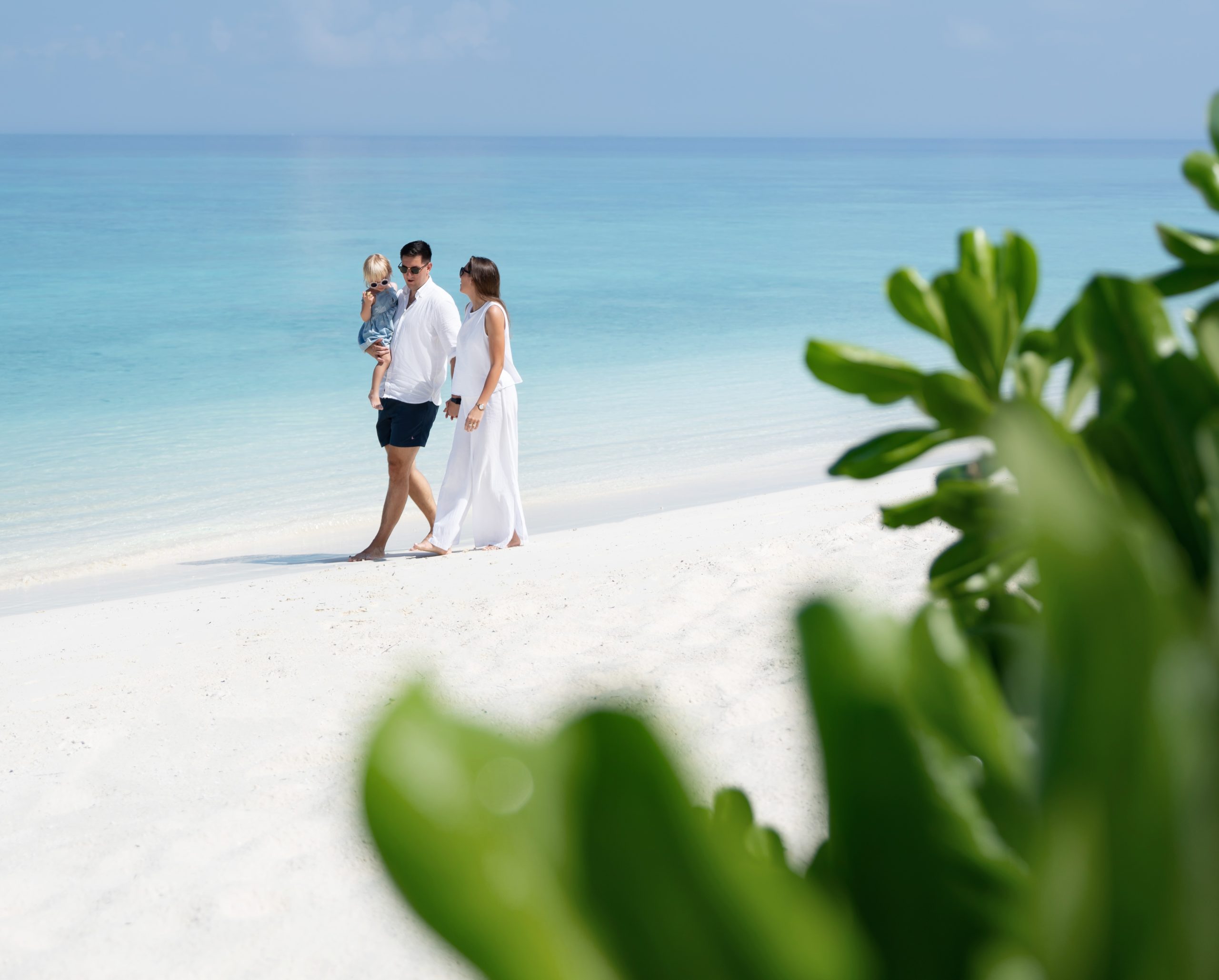 Famiglia che cammina sulla spiaggia alle Maldive