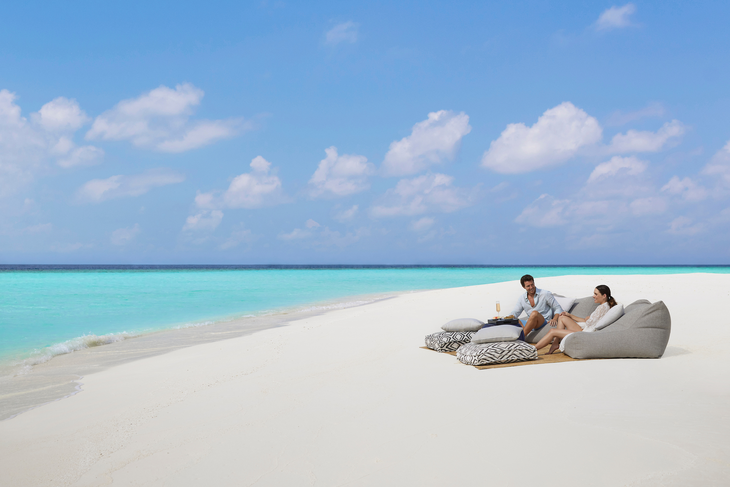 Famiglia che cammina sulla spiaggia alle Maldive